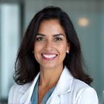 Dr. Jennifer Patel, a smiling South Asian woman in medical scrubs, looking empathetic.