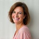 Portrait of Jennifer, a smiling woman in her late 40s or early 50s.